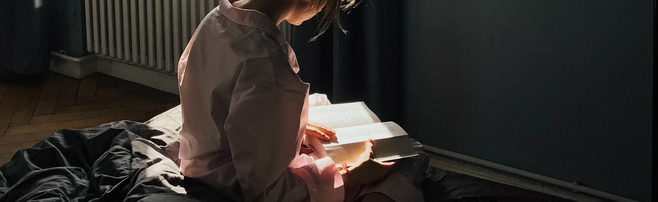fille lisant un livre sur ses genoux