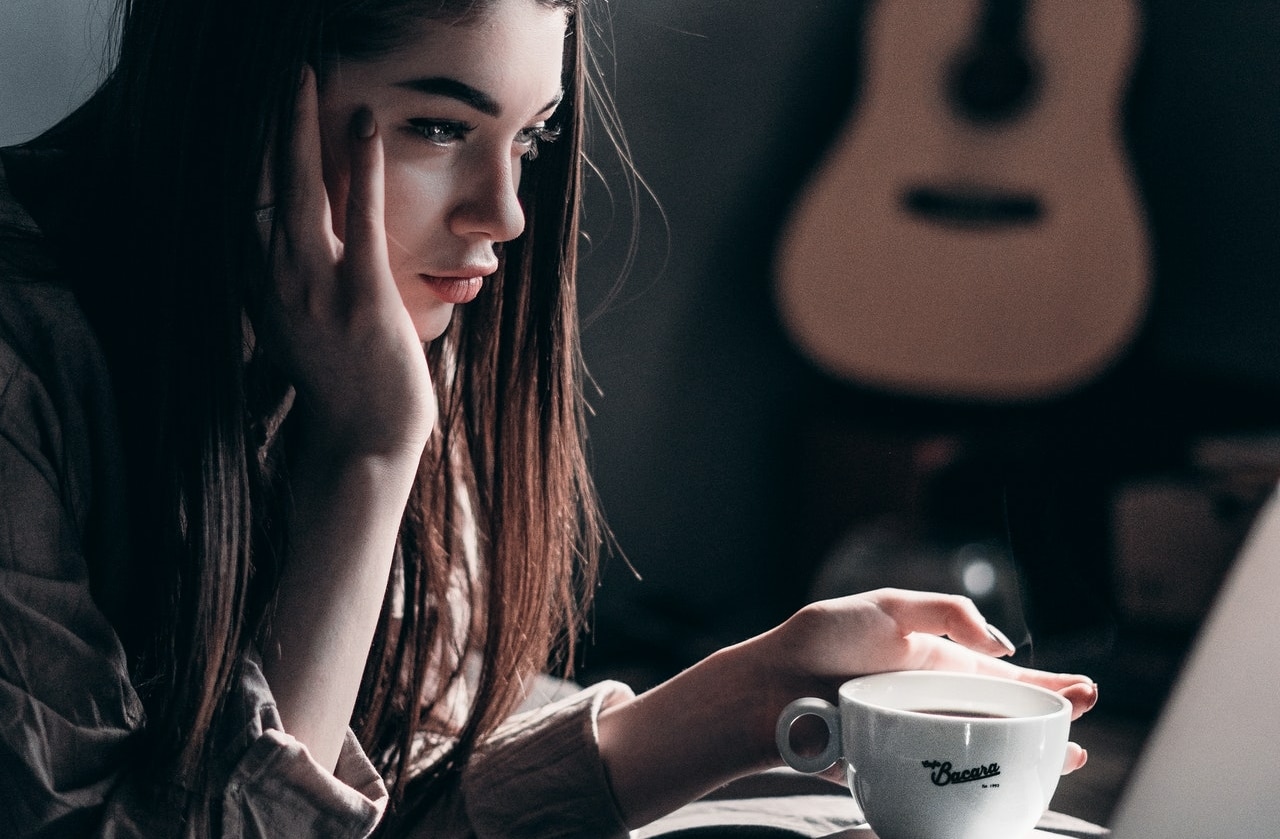 girl drinking coffee and working on a pc