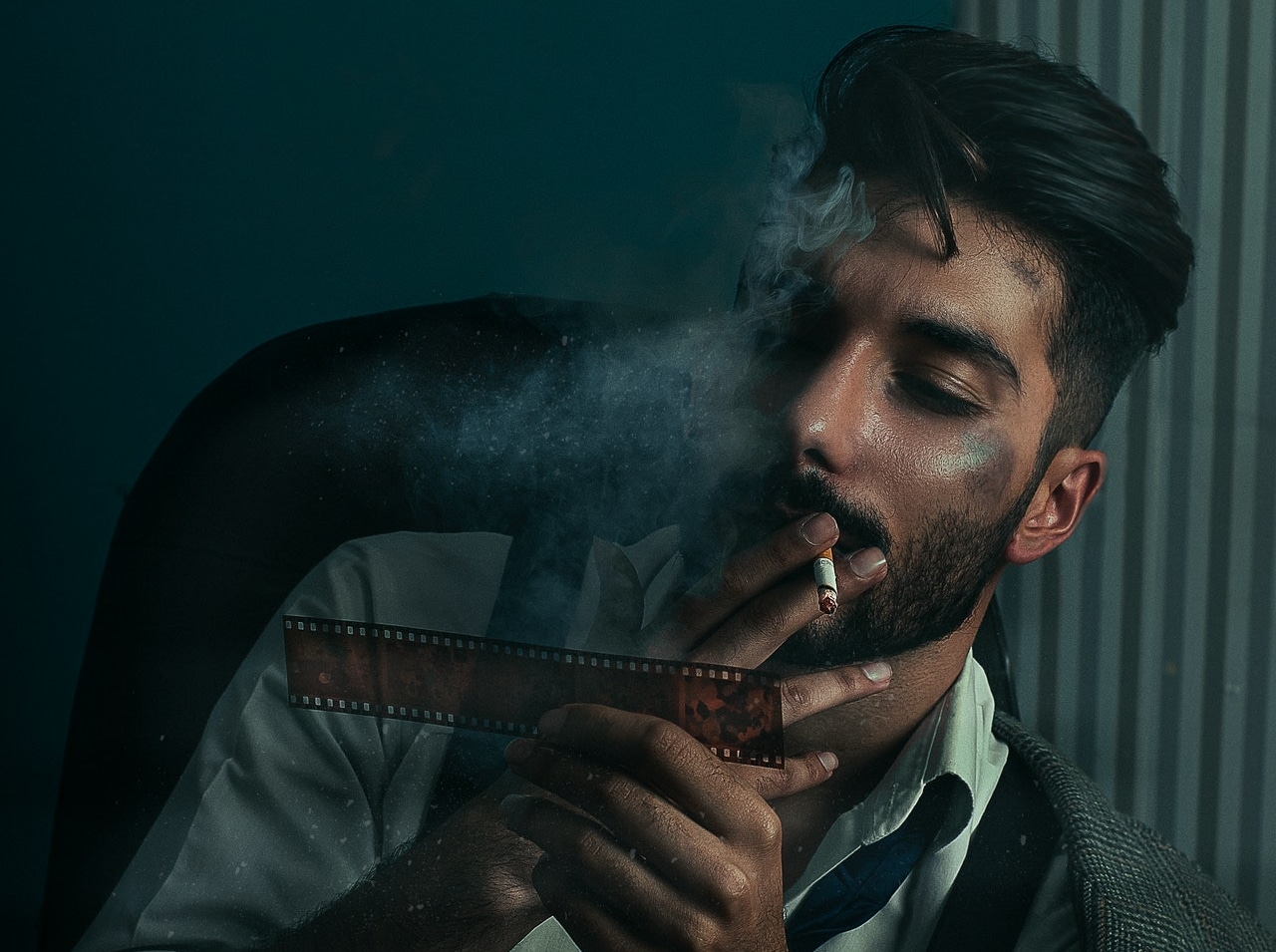 man smoking a cigarette while looking at a film