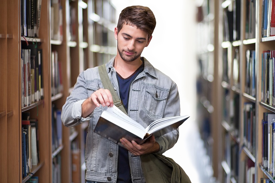 man reading a book in a library