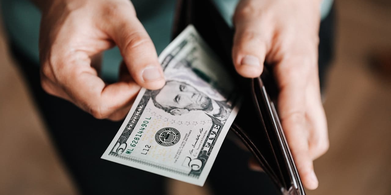 man taking a dollar bill out of a wallet