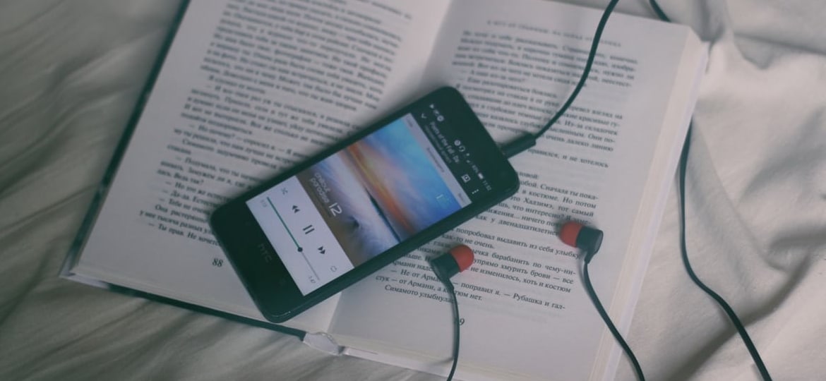 smartphone with headphones on a book