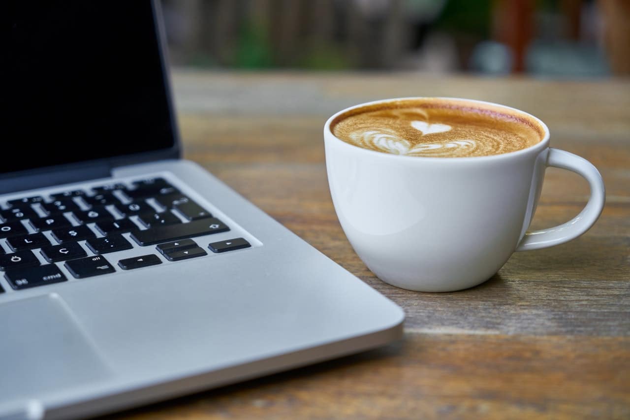 cup of coffee near a laptop