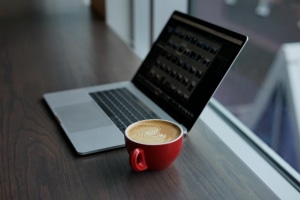 ordinateur ouvert avec tasse de café à côté