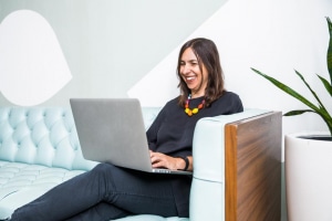 femme moderne et souriante trvaille sur son ordinateur