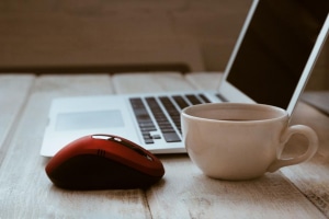 a-computer-mouse-and-a-cup-of-coffee-near-a-computer