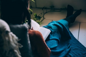 personne assise par terre et lit un livre