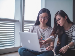 two girls looking at a computer screen