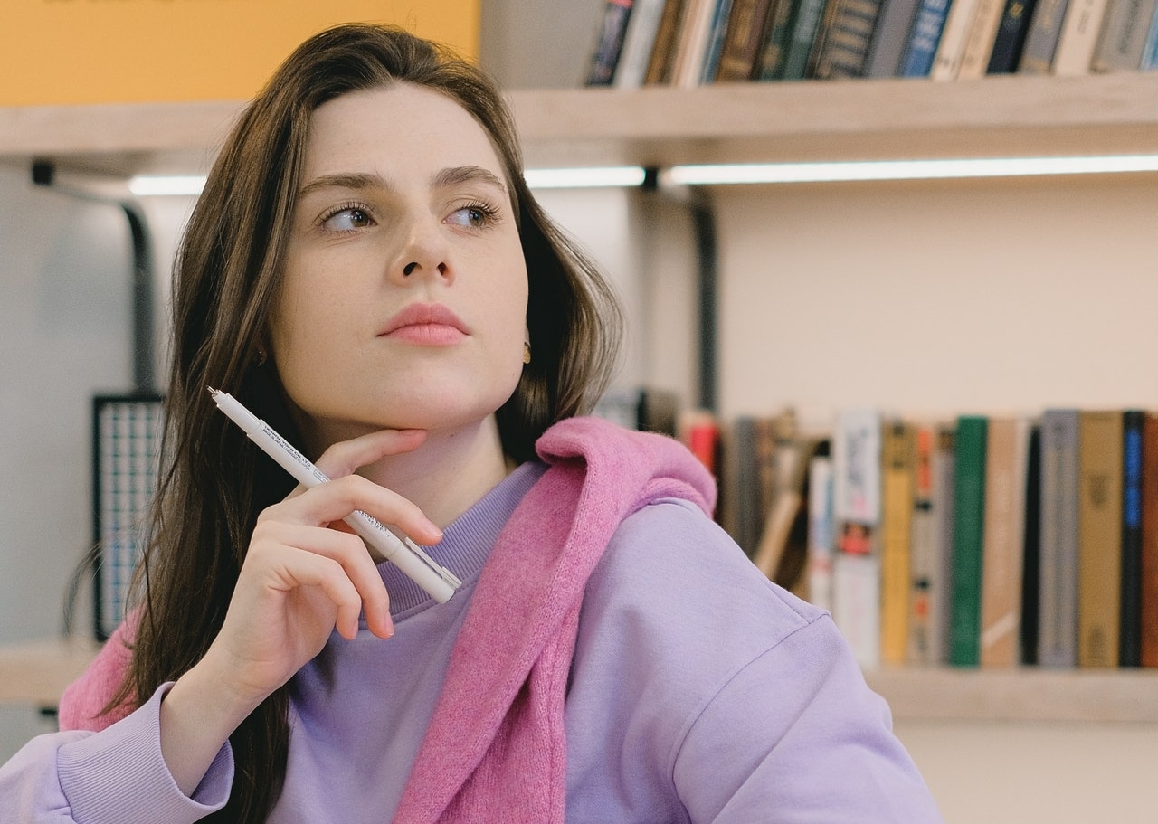 girl thinking with a pen in her hand