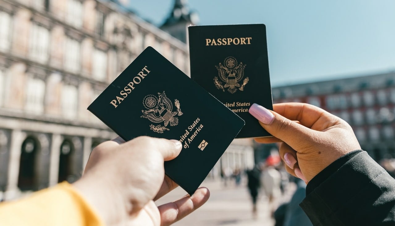 two people holding usa passports