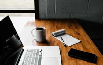 cup of coffee and a notebook on a table