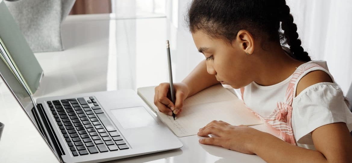 little girl studying on her laptop