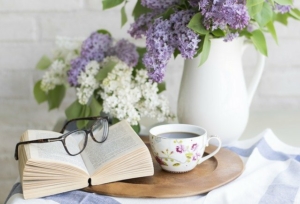 table-with-tea-book-flowers-glasses