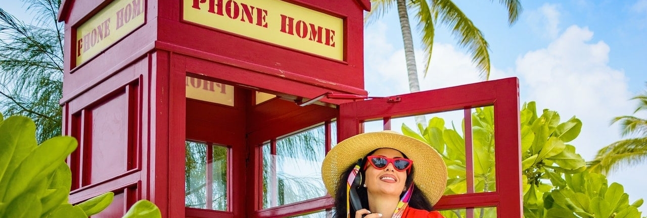 woman speaking in front of a phone box