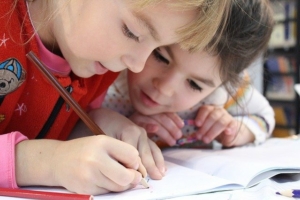 little-girls-writing-on-a-sheet-of-paper