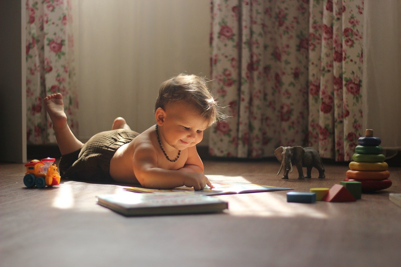 baby reading a book on the floor