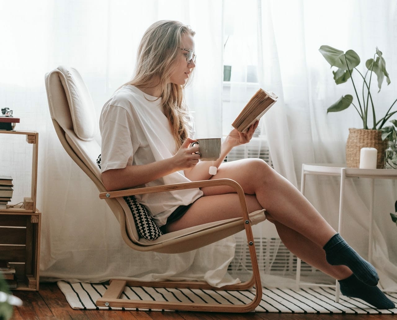 girl reading a book on a chair