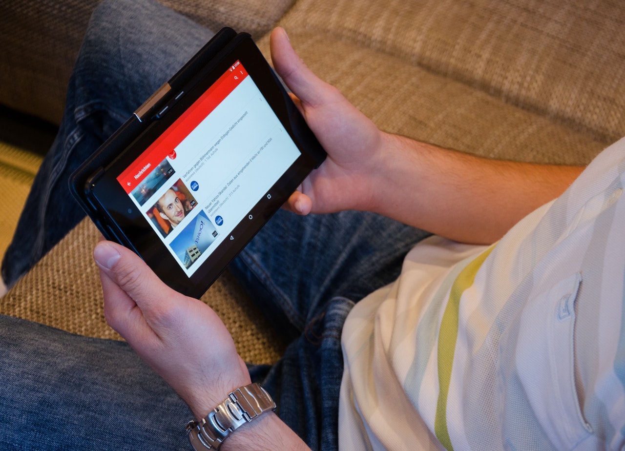 man watching youtube on his tablet