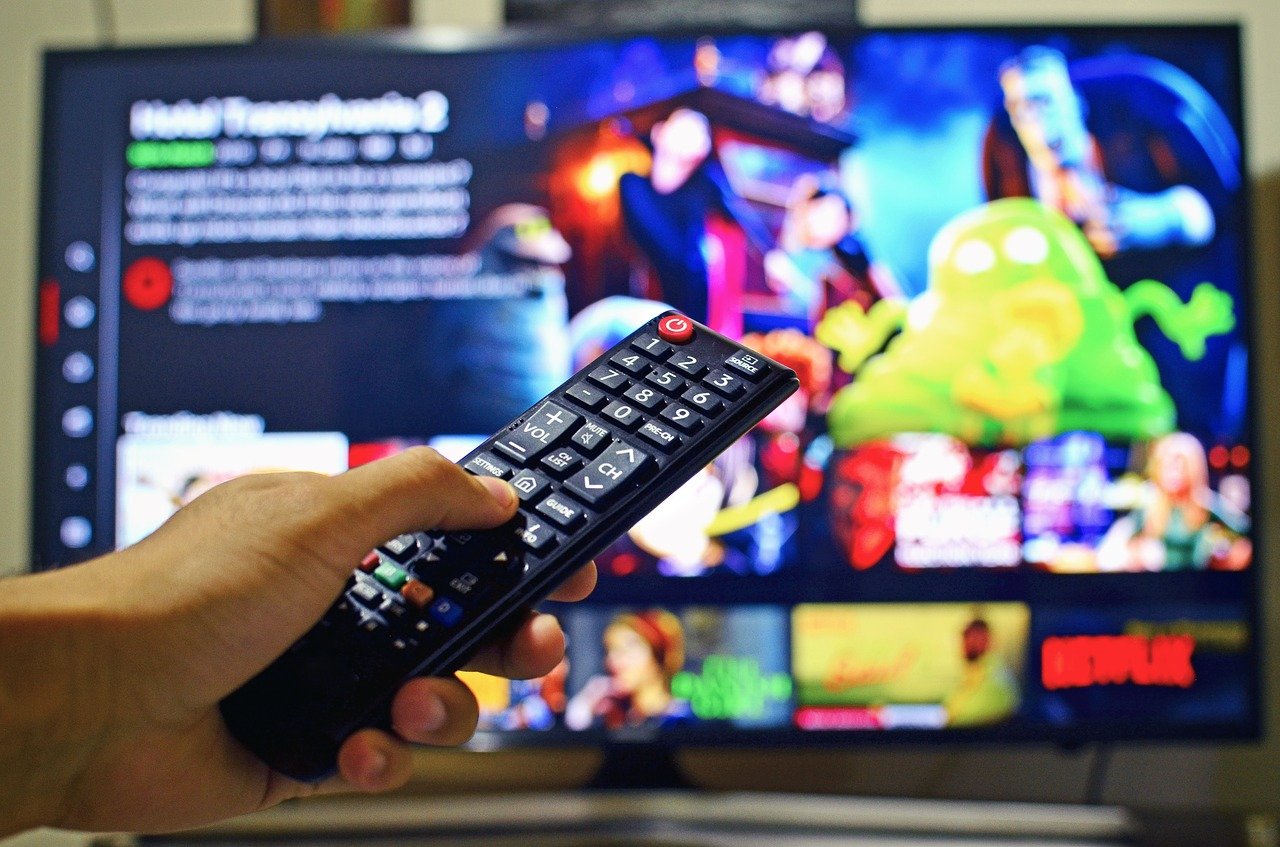 person holding a remote control in front of a tv
