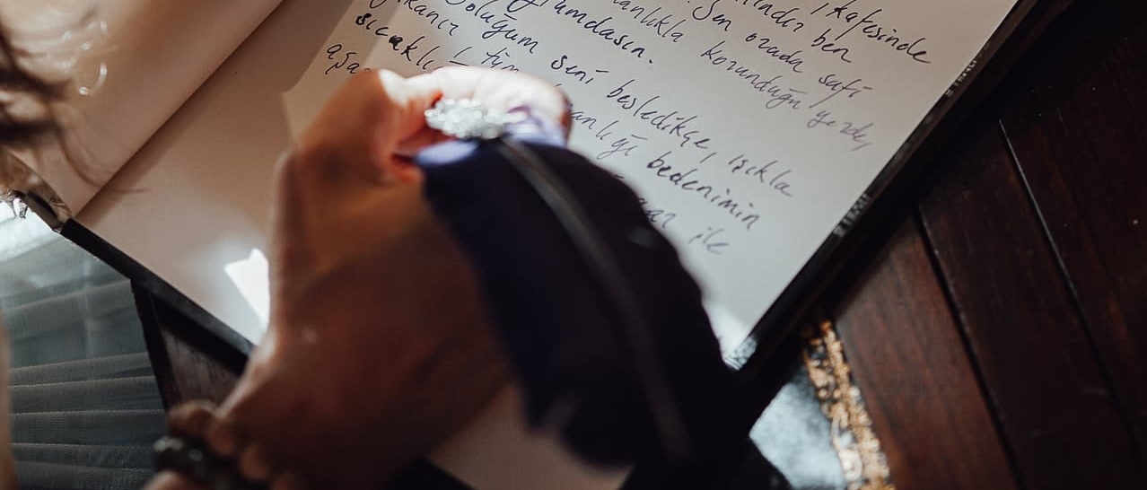 man writing with a feather pen 