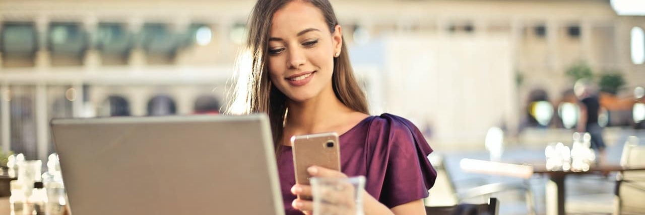 girl smiling and texting on her phone at a bar