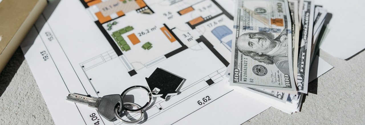 house keys and money on an architecture plan