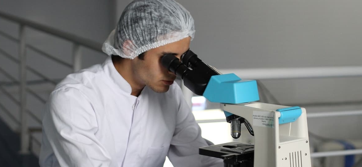 a scientist looking through a microscope