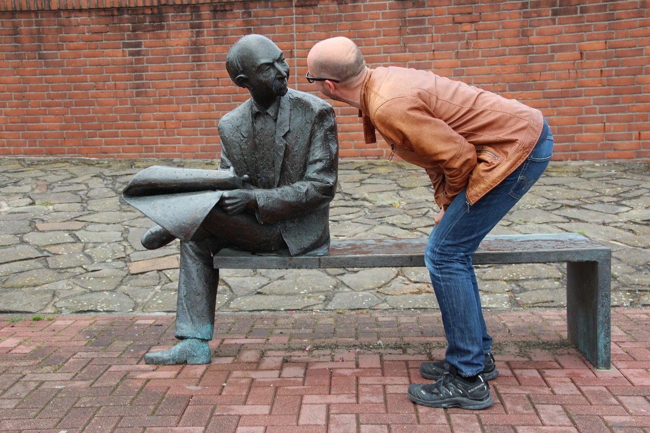 man speaking to a statue