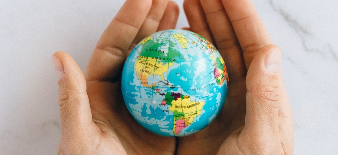 person holding a globe in their hands