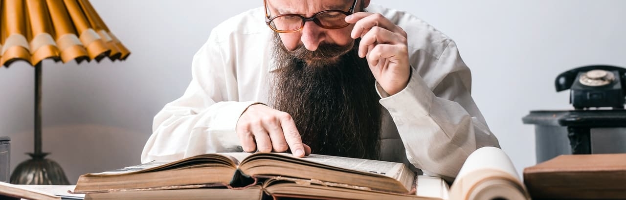 vieux homme barbu qui étudie un livre